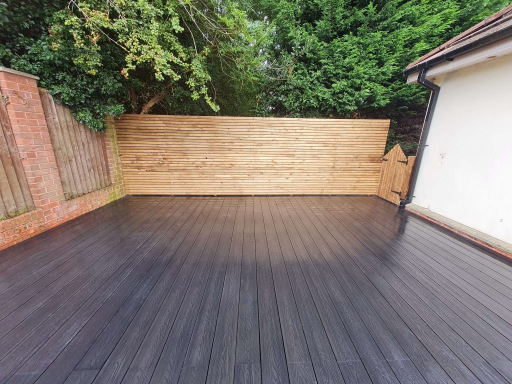 Dark garden decking with timber slatted fencing in Staffordshire