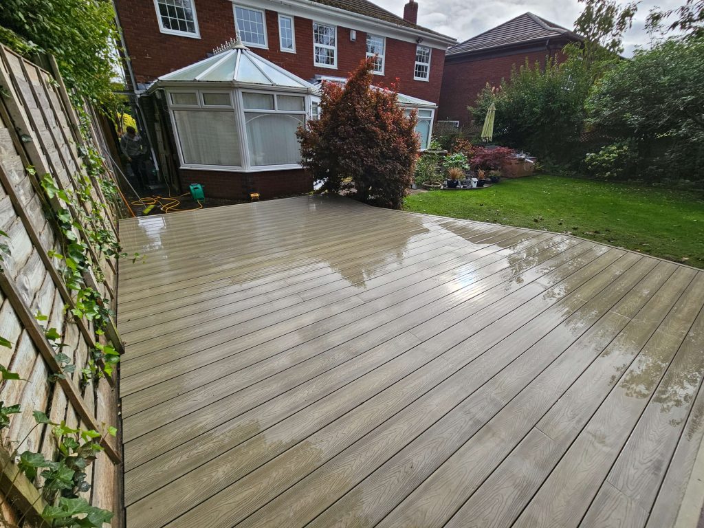 Large garden decking area beside lawn in Staffordshire