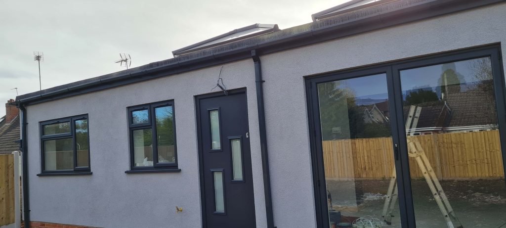 Rendered house exterior with black windows, doors and guttering in Staffordshire