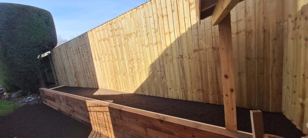 Timber garden fencing with raised sleeper planter beds in Staffordshire