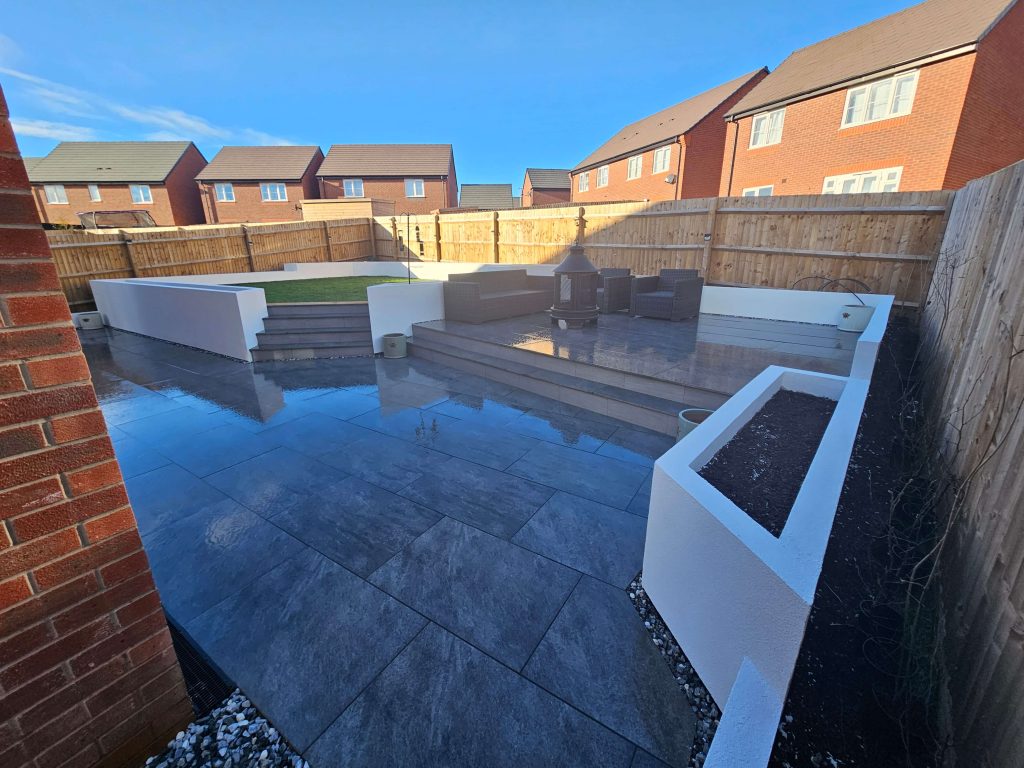 Modern landscaped garden with patio, raised lawn and rendered planters in Staffordshire