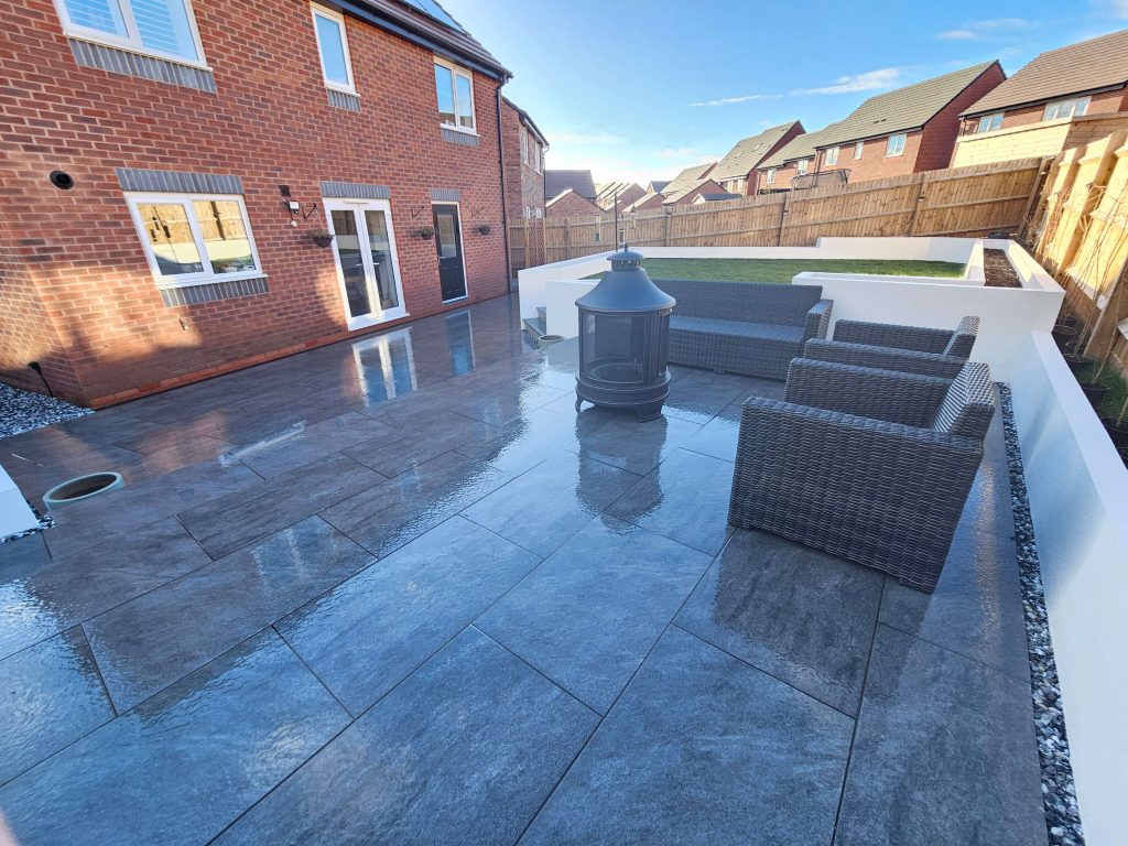 Modern garden patio with raised lawn and rendered walls in Staffordshire