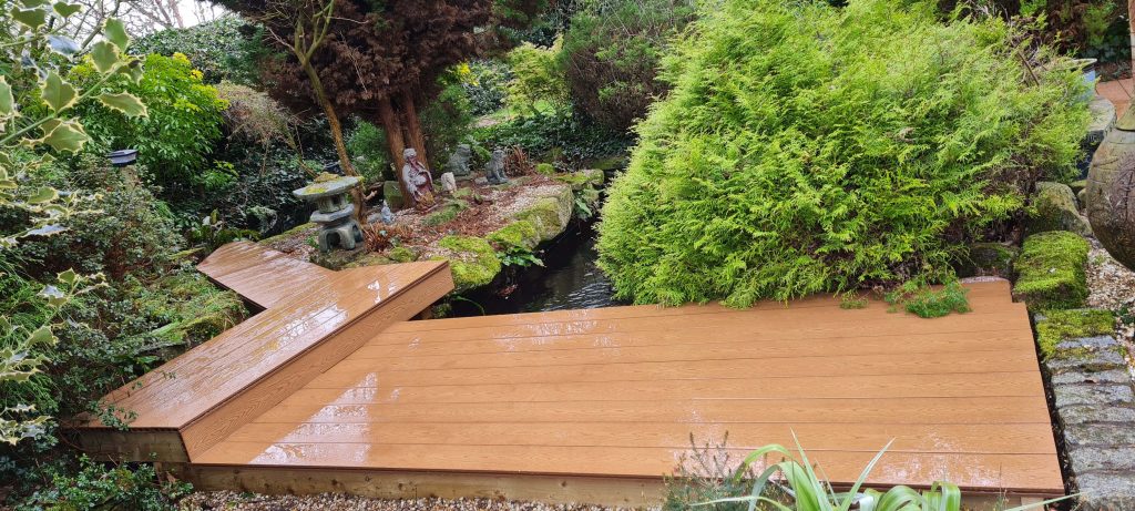 Garden decking beside pond and mature planting in Staffordshire