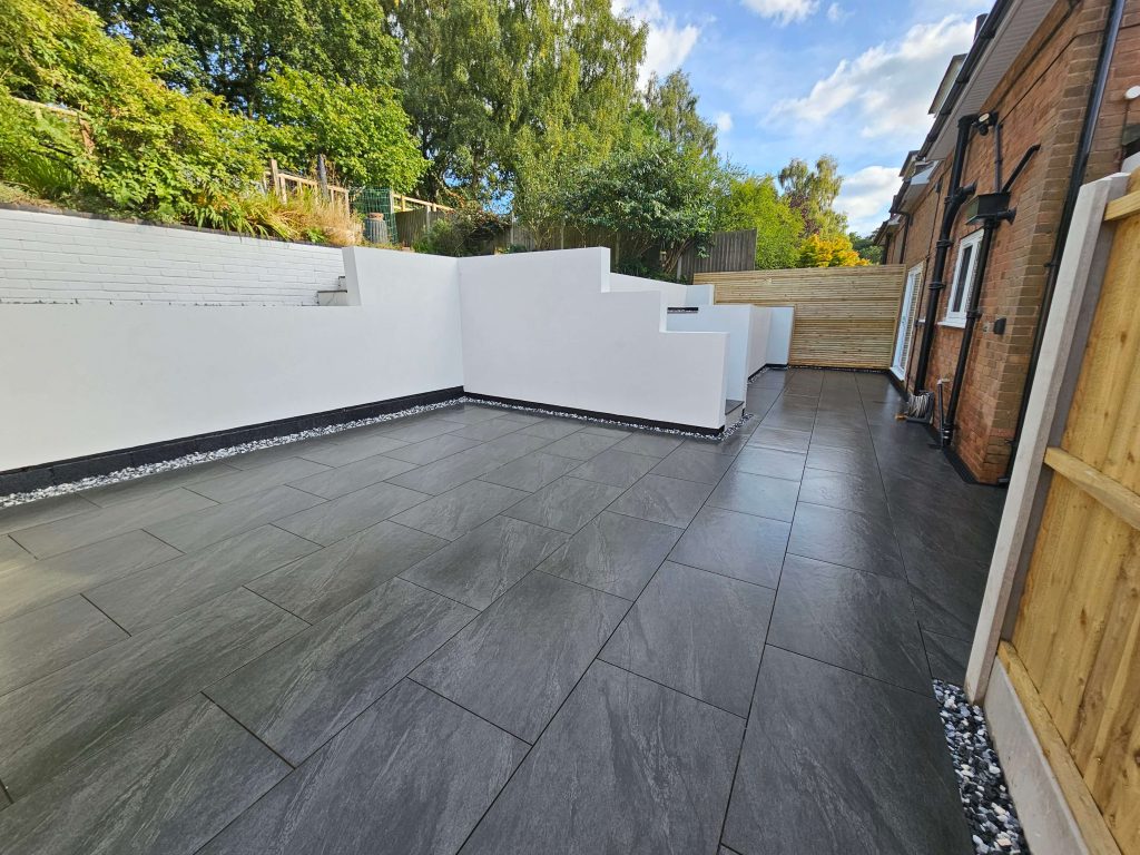 Modern garden with dark patio tiles and white rendered walls in Staffordshire
