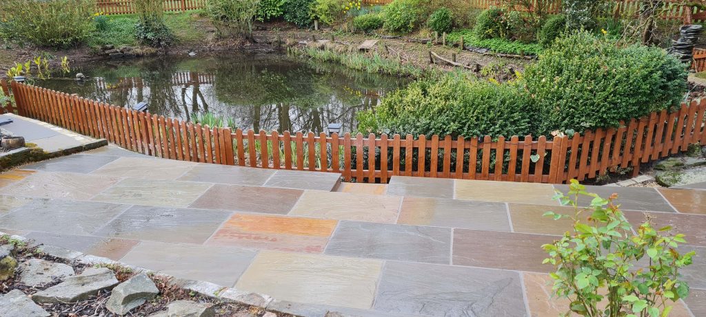 Natural stone paving beside garden pond in Staffordshire