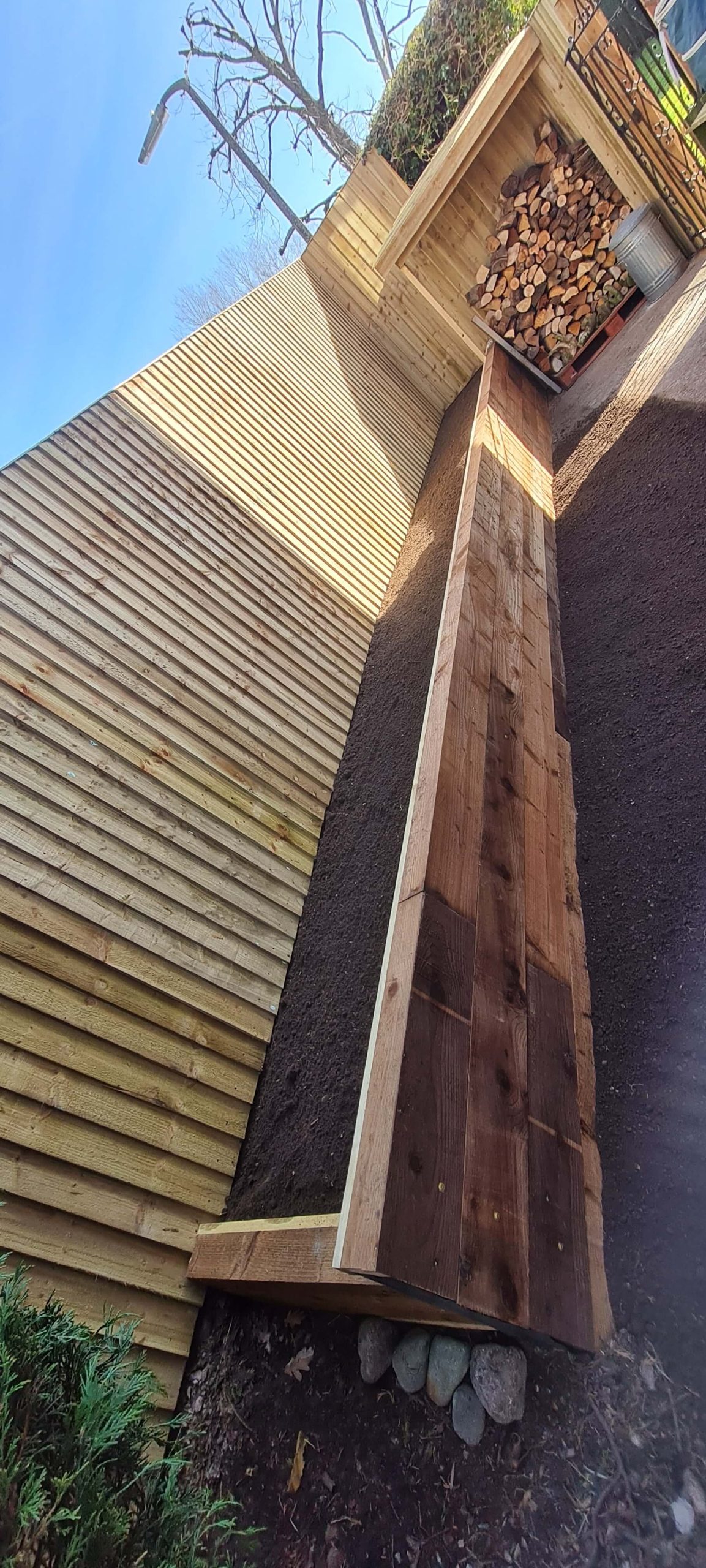 Timber fencing with raised sleeper beds and log store in Staffordshire